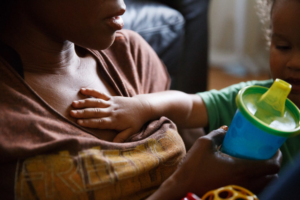 A little boy puts his hand on his mom's chest - Highland Park, Los Angeles, CA
