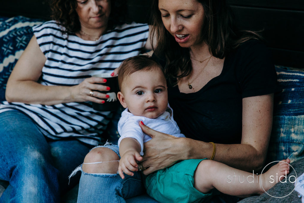 Two moms hold their baby and drink coffee in Silver Lake, Los Angeles, CA