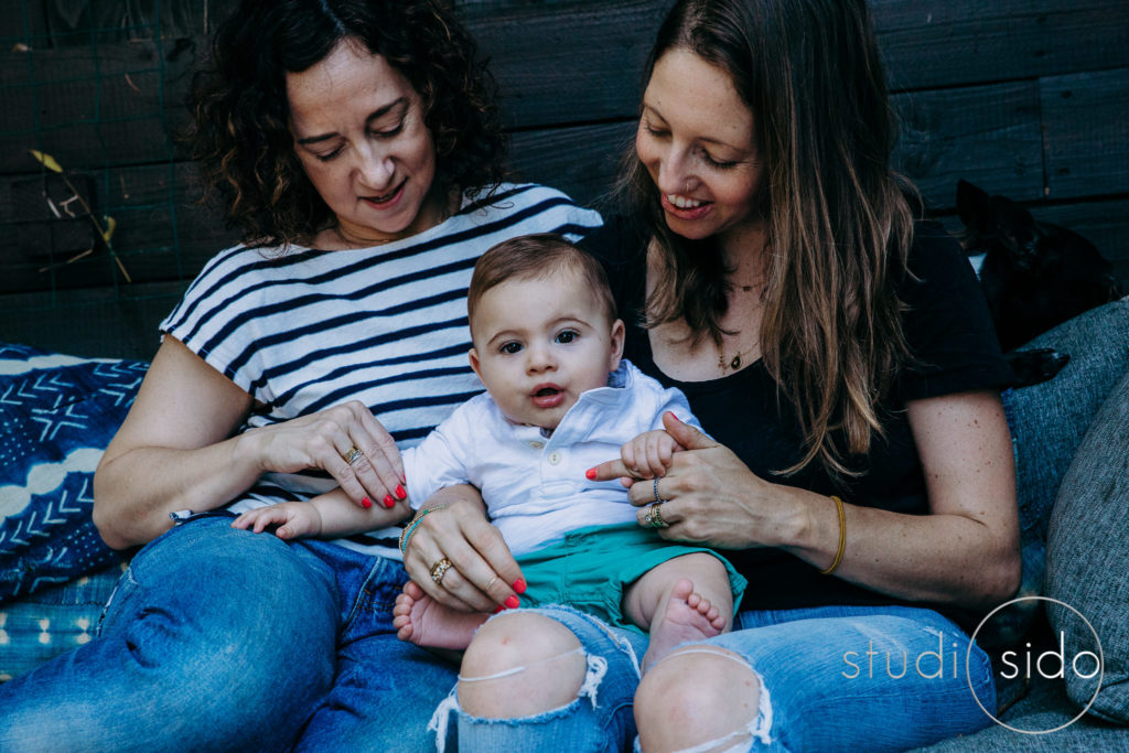 Two moms cuddle their son in LBGTQ family