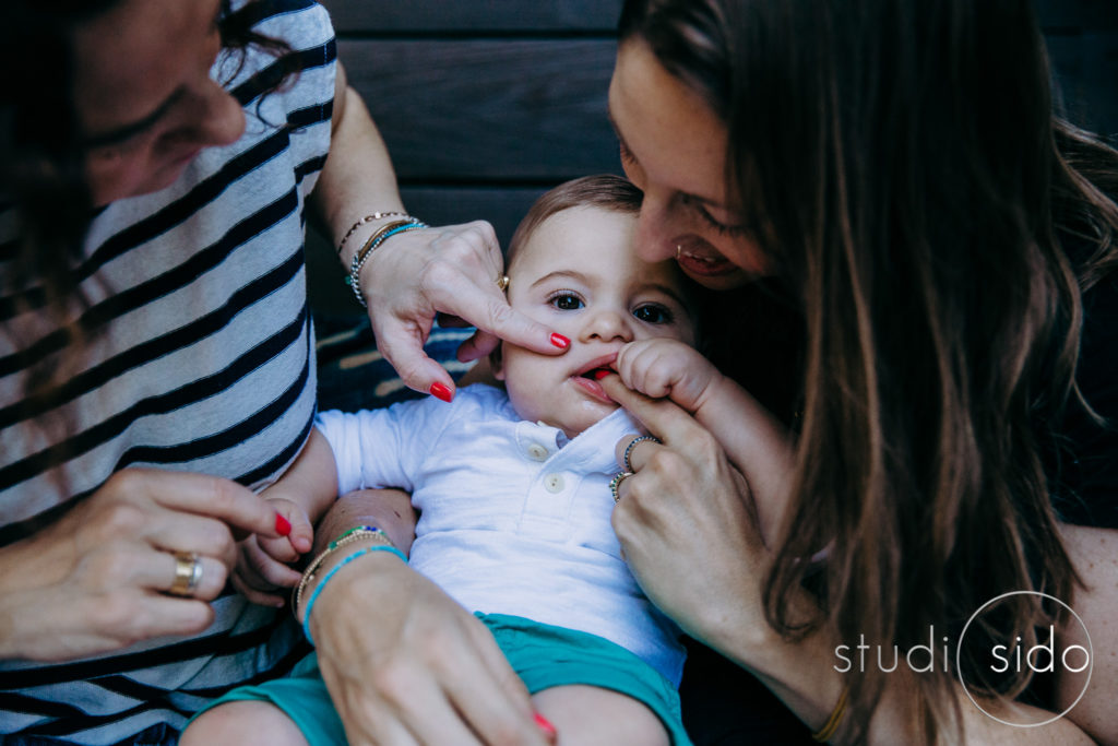 Two mamas touching their baby, outside in Silver Lake, Los Angeles, CA