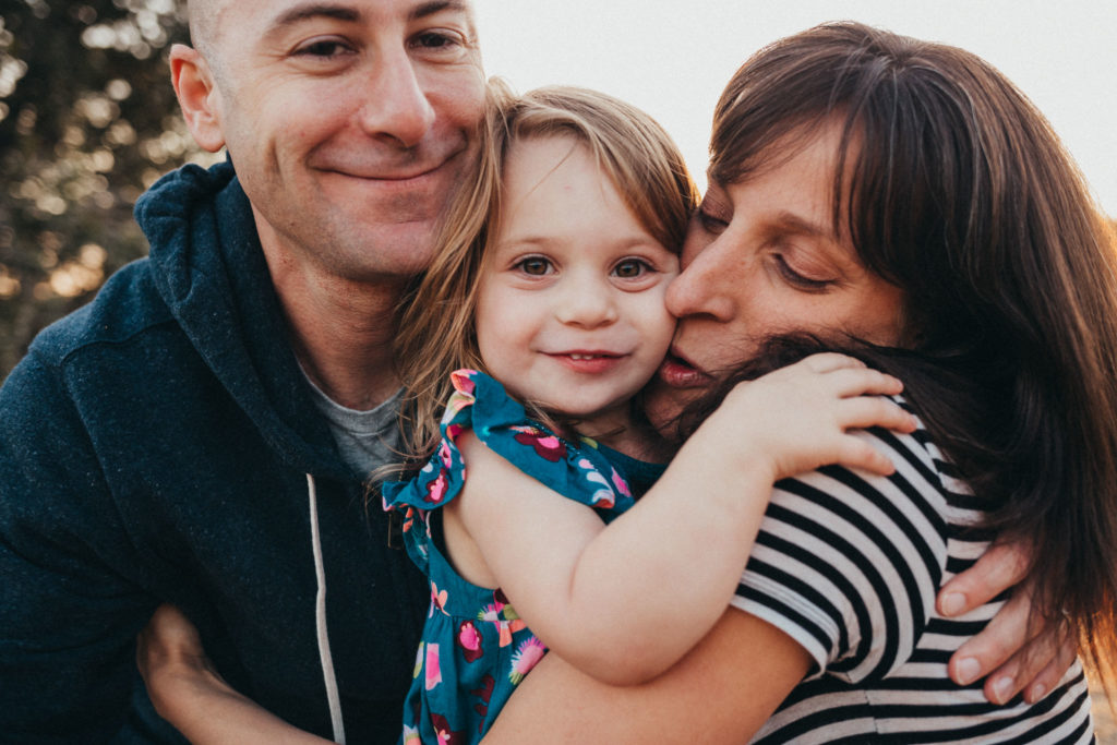 Family photograph - mom, dad, and daughter all cuddled in close