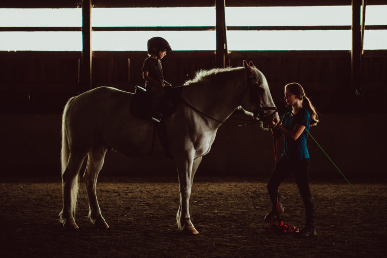 Photograph of young boy on a horse with trainer