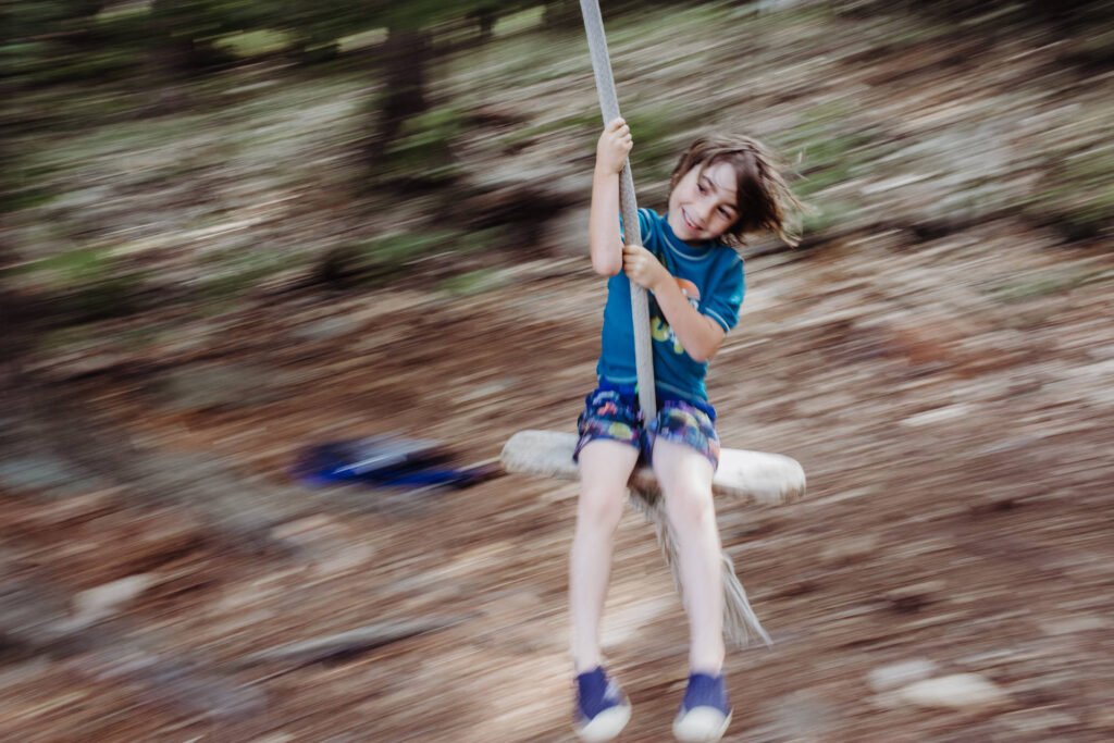 Boy swings on a rope swing