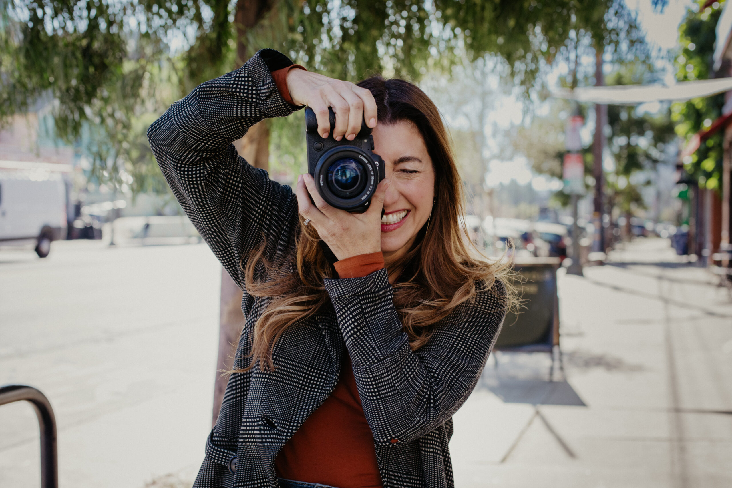 sarah sido holding camera, a photographer that uses the simple sales blueprint